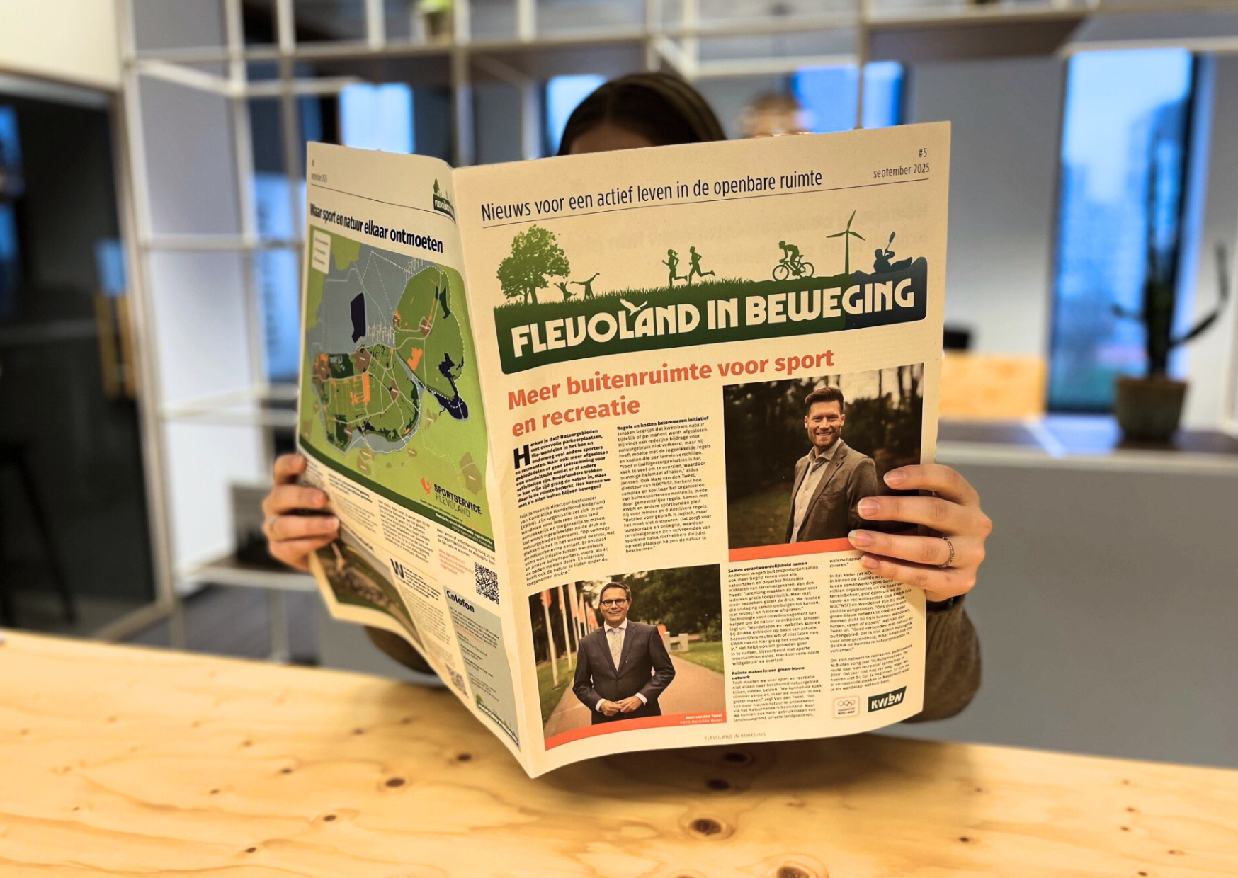 Vrouw leeft de krant Flevoland in Beweging in kantoorsetting